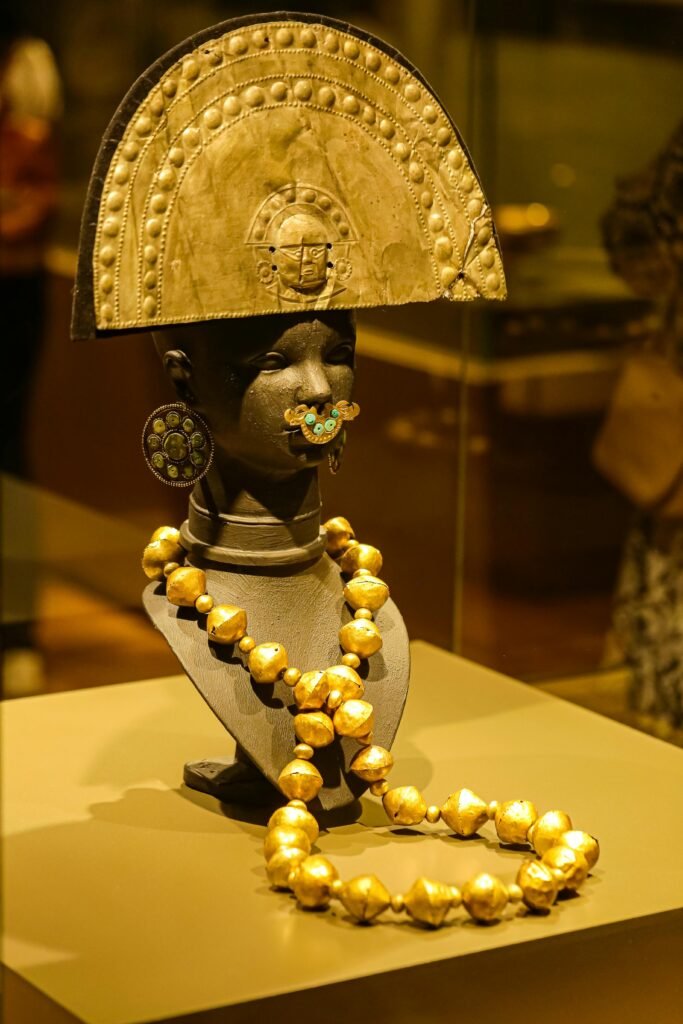 Ancient gold jewelry in a museum exhibit, showcasing a detailed headdress and necklace.