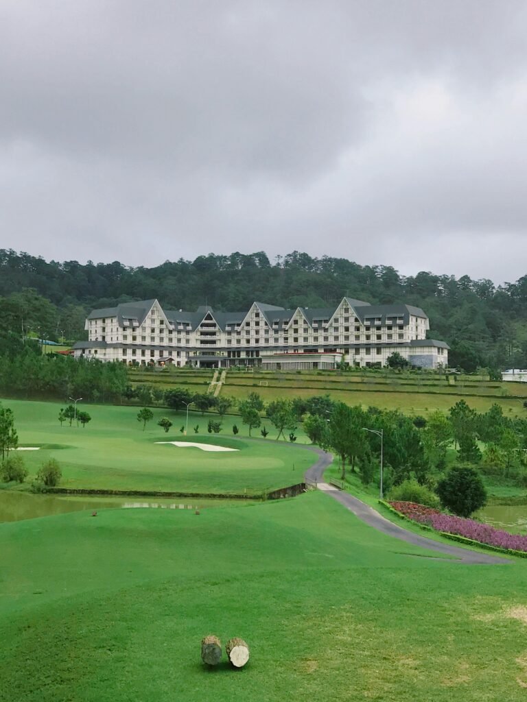 Scenic view of a resort nestled amidst lush green fields and hills, perfect for a relaxing getaway.