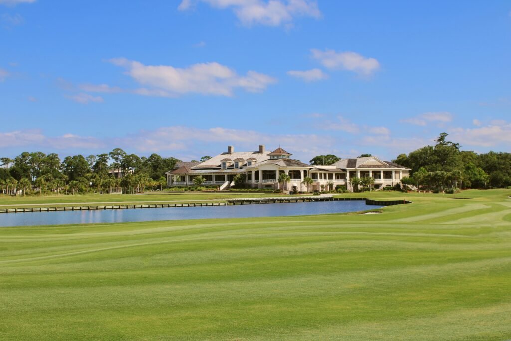 Stunning view of a golf course with a serene lake and clubhouse on Hilton Head Island.